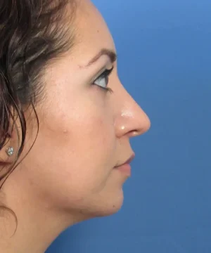 Profile view of a person with long brown hair against a blue background.