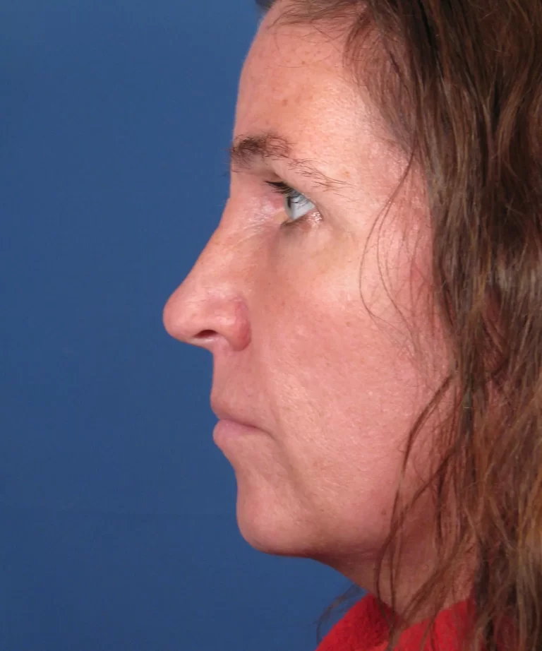 Profile view of a person with long brown hair against a blue background.